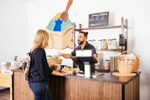 istock Cheerful Storekeeper Serving Customer in Bright Grocery Store During Daytime 2151903744
