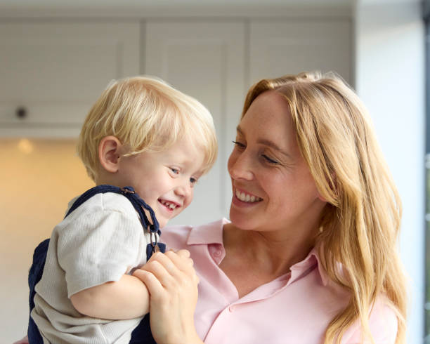 istock Loving Mother Cuddling Young Son At Home In Kitchen Together 2151909625