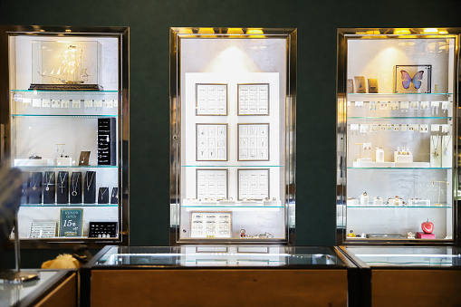 A high-end custom jewelry store. There are all kinds of high-end jewelry in the store, neatly arranged in display cabinets for customers to view and purchase.