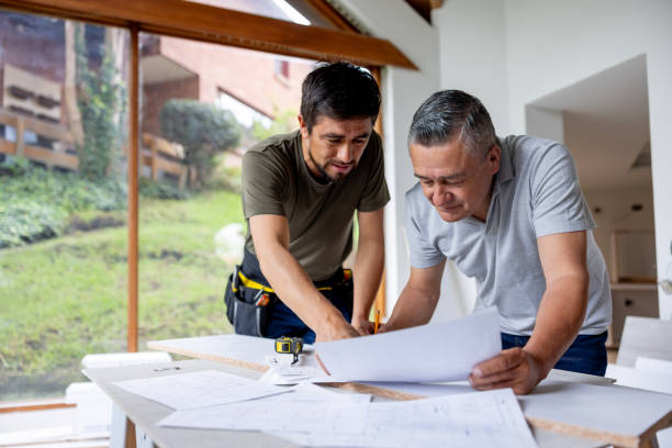 istock Architect and building contractor looking at blueprints while remodeling a house 2151912550