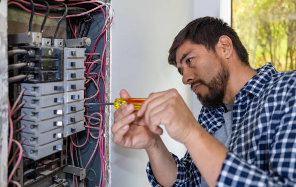 Electrician fixing a fuse box at a house Latin American electrician fixing a fuse box at a house and using a screwdriver control panel stock pictures, royalty-free photos & images