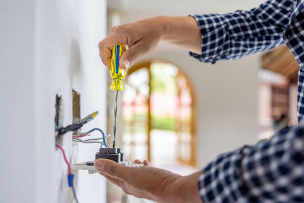 Electrician installing a power outlet while remodeling a house