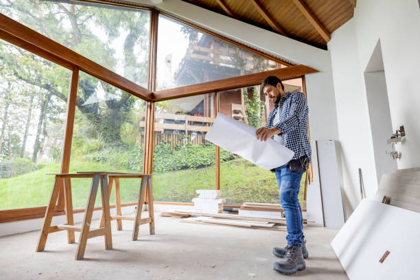 istock Architect remodeling a house and looking at a blueprint 2151912571