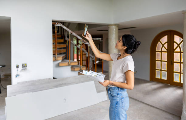 Architect remodeling a house and taking pictures with her cell phone