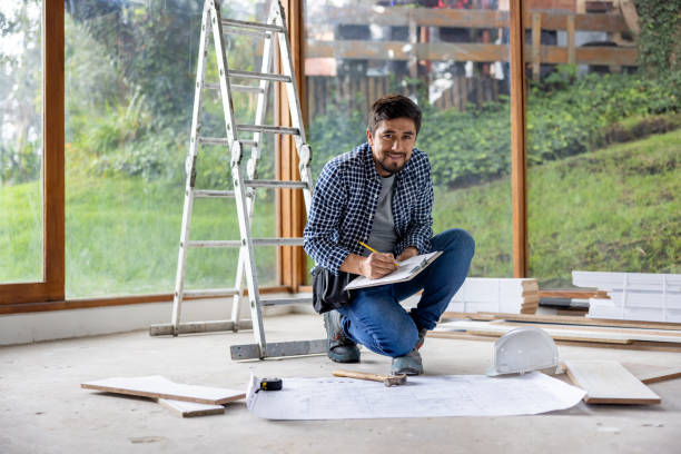 istock Architect renovating a house and looking at a blueprint 2151912595