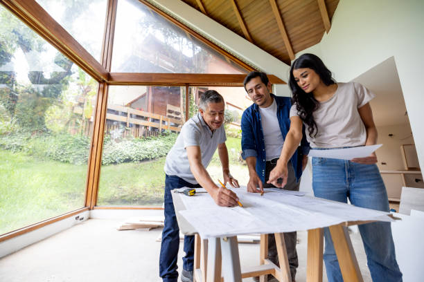istock Building contractor looking at blueprints with a couple remodeling their house 2151912607