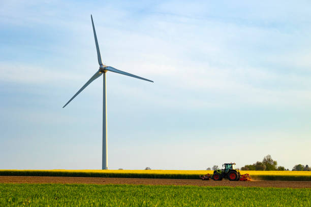 istock Wind turbines with a farm tractor 2151912881