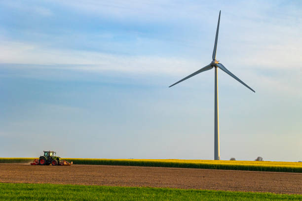 istock Wind turbines with a farm tractor 2151912917