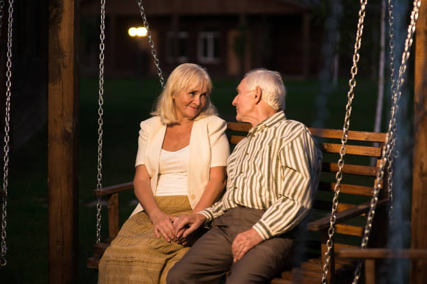 A loving elderly couple sharing a beautiful moment of affection in a peaceful and serene outdoor setting