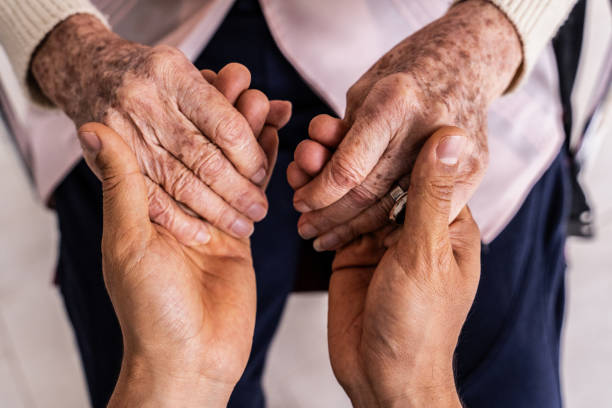 close-up of a caregiver holding hands senior woman patient - ouderenzorg stockfoto's en -beelden