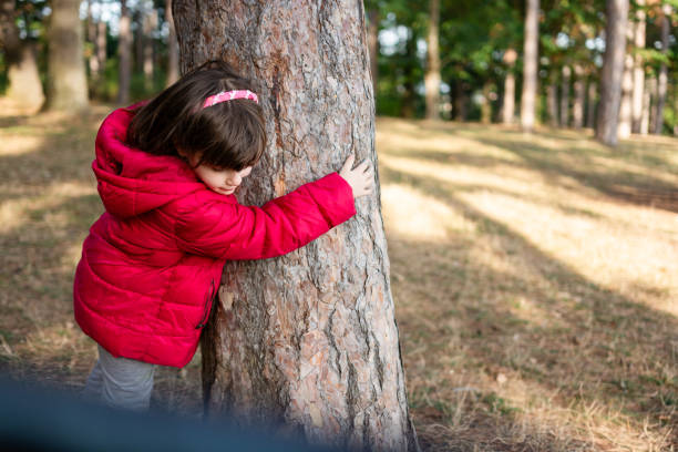 istock Little girl embracing tree in the park 2151922266
