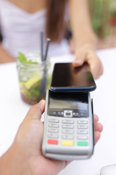 istock Woman is paying for drink with cell phone. Payment concept with NFC technology 2151924683