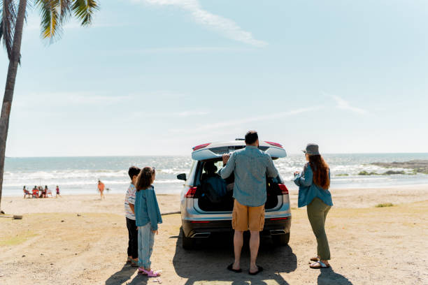istock Family unloading luggages from the car trunk on the beach 2151927185