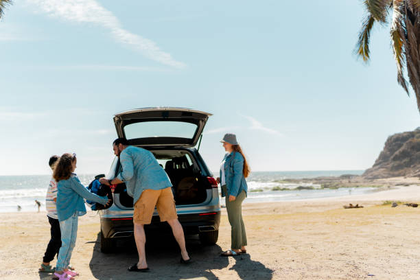 istock Family unloading luggages from the car trunk on the beach 2151927186