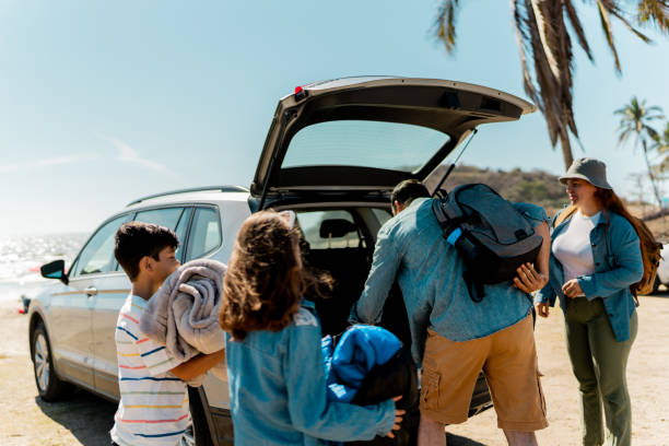 istock Family unloading luggages from the car trunk on the beach 2151927209