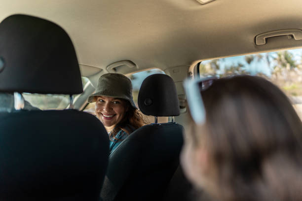 Mother talking with daughter insider a car