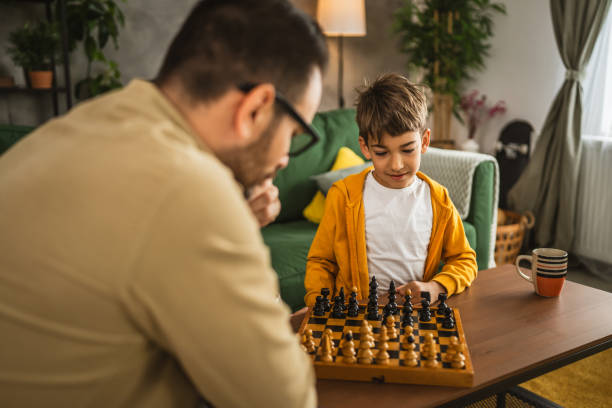 istock Father and son play chess together at home 2151928554