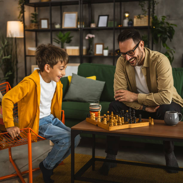 istock Father and son play chess together at home 2151928658
