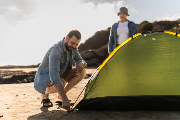 istock Couple setting up tent on the beach 2151928809
