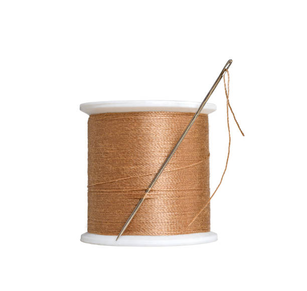 istock A spool with brown orange color sewing thread with a needle isolated cutout 2151930253