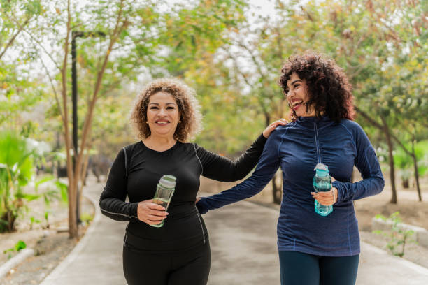 istock Mother and daughter talking and walking through the public park 2151931377