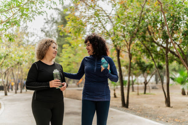 istock Mother and daughter talking and walking through the public park 2151931394