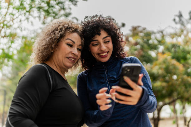istock Young woman and mother using mobile phone on the public park 2151931396