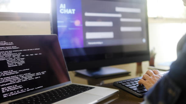 AI chatbot: Programmer using artificial intelligence for software development inside office. Virtual chat Bot technology trend stock photo