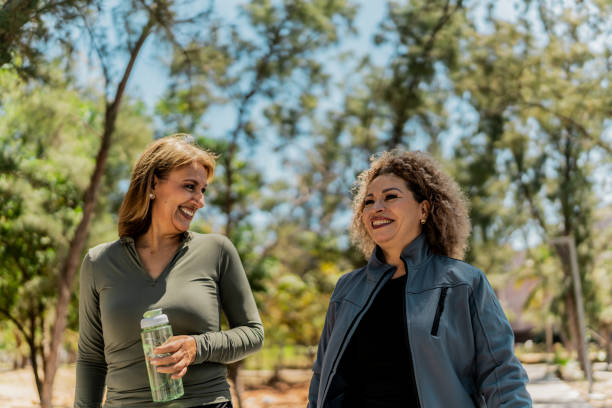 istock Senior women talking and walking thorugh the public park 2151931789