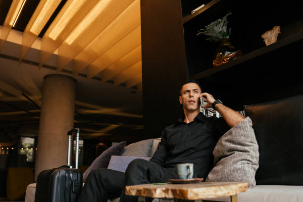 istock Businessman using smartphone in hotel lounge 2151935775