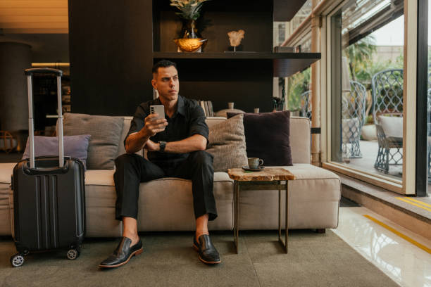 istock Businessman using smartphone in hotel lounge 2151935797