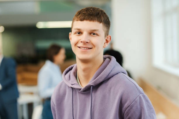 istock Young smiling man, IT specialist, student working in modern office, standing on university campus 2151937281