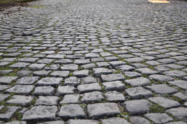 Gray Old Paving Stone Texture. Granite Sett. Stone Block Seamless Tileable. Cobblestone pavement texture background. Detail of granite sidewalk. Top view of stone road. Vintage pavement with rough block.An overhead view of patterned stone cobbles, making up the surface textura gris de adoquín viejo. asentamiento de granito. bloque de piedra sin costura azulejo sin costura.fondo de textura de pavimento de adoquines. detalle de acera de granito. vista superior del camino de piedra. pavimento vintage con bloque rugoso
