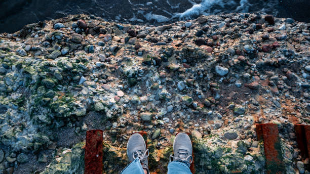 istock A person is standing on a ledge with their feet on a railing 2151939626