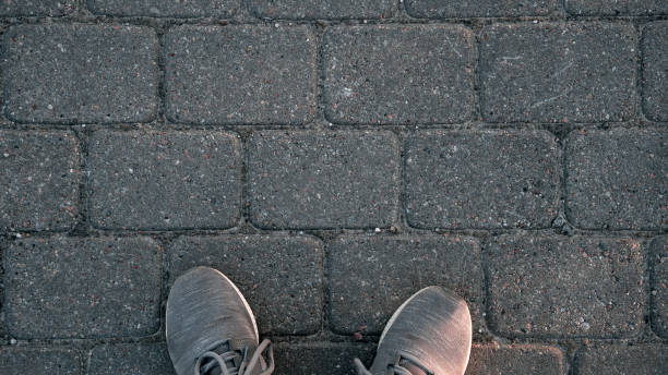 istock A person's feet are on a brick sidewalk 2151939698