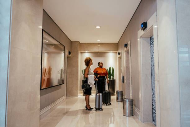 istock Two businesswomen talking while waiting for the elevator at the hotel 2151939974