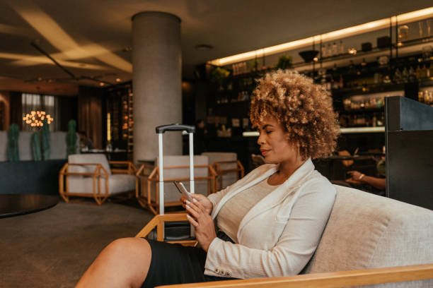 istock Businesswoman using smartphone sitting in hotel lobby 2151939990
