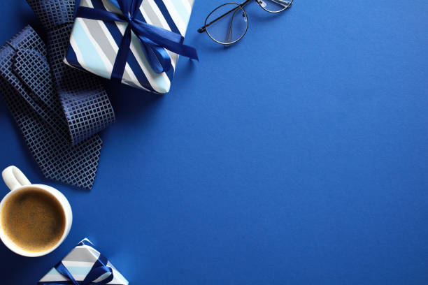 istock Flat lay composition with gift boxes, coffee cup, tie, glasses on dark blue background. Happy Fathers Day concept. 2151940907
