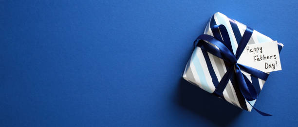 istock Happy Fathers Day gift box on dark blue background with space for text. Father's Day banner template. 2151941176