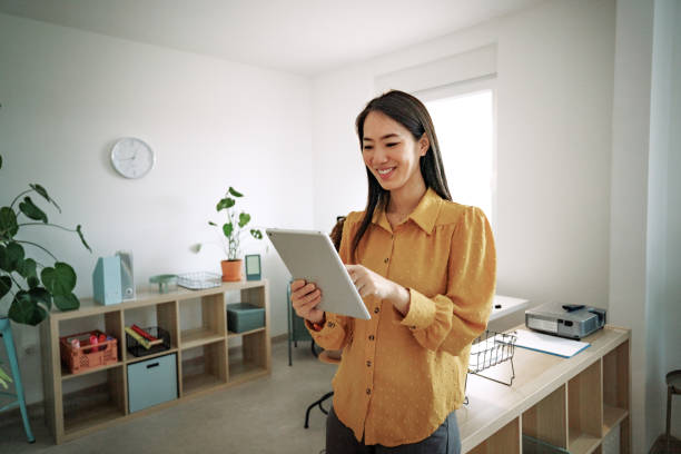 istock Smiling well dressed businesswoman using digital tablet at small office 2151941638