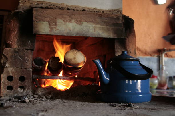 teapot in front of the fireplace with a fire burning in it