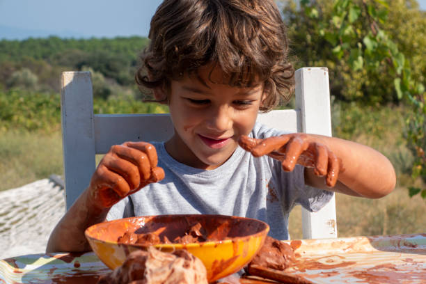 istock Boy playing with ceramic clay. He works for his creativity. A 9-year-old boy playing with ceramic clay in a bowl. He works at the table on the porch of the house. 2151943548