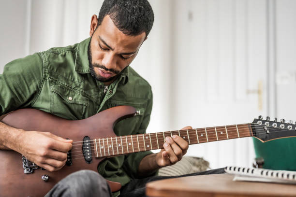 istock Focused Musician Practices Guitar Indoors 2151945738