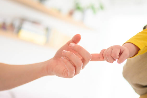 tender moment captured as a newborn's tiny fingers grasp the finger of their father, symbolizing love, connection, and the bond between parent and child