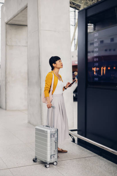 Young Asian Woman Checking Flight Schedule at Airport