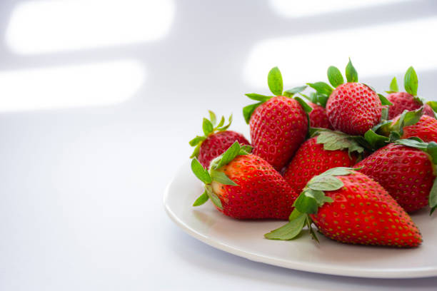 A strawberry cut in half with yellow backboard.