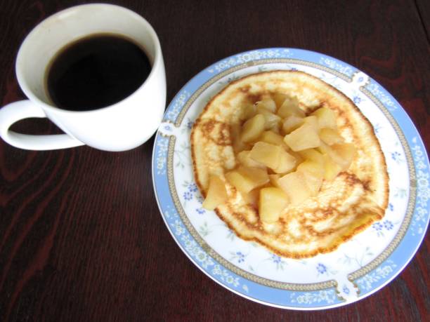 Close-up of a freshly cooked pancake with a golden brown surface on a green plate.