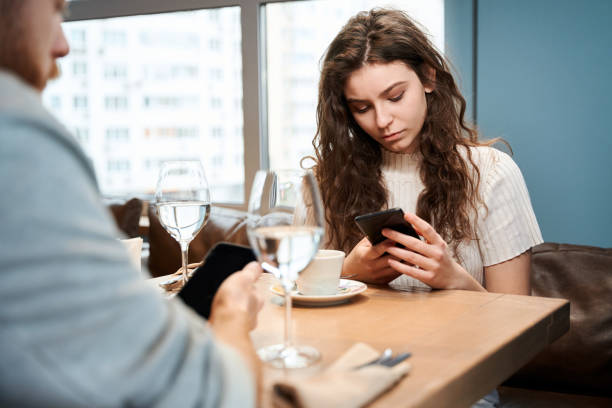 istock Young couple in cafe using their phones 2151948768