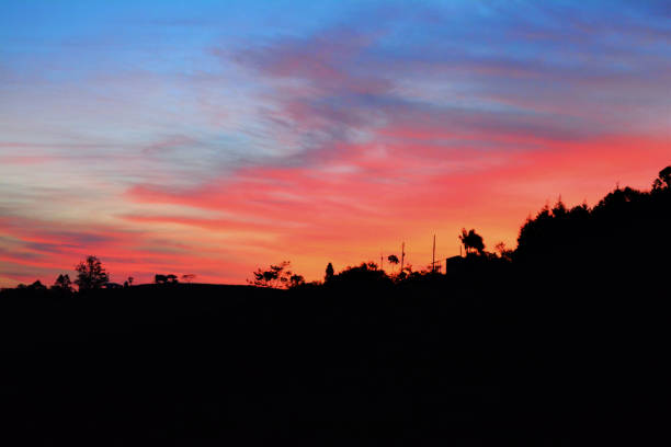 The fiery hues of sunset washing over the rugged peaks and volcanic formations of the Warrumbungle Range.