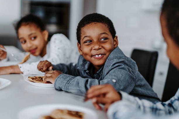 istock Happy black boy eating breakfast with his siblings 2151959768